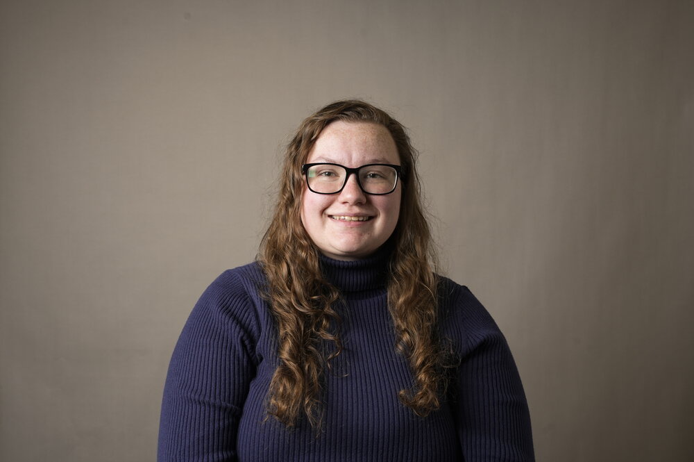 picture of amy vandervelde, a woman wearing a blue sweater and glasses